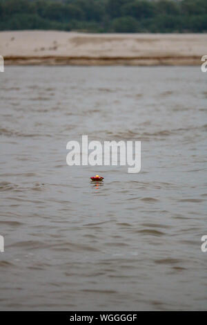 Candela galleggiante sul Fiume Gange a Varanasi dopo una cerimonia puja, India Foto Stock