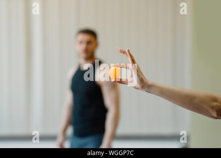 Mano femmina trattiene il ping pong ball, ping pong Foto Stock