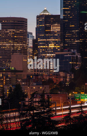 Immagine retrò dello skyline di Seattle al tramonto, con luci della città e traffico automobilistico sulla i-5 Foto Stock