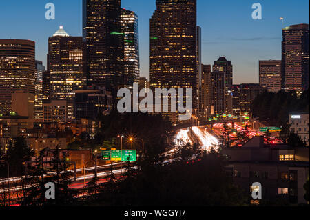 Seattle skyline tramonto con le luci della città e il traffico automobilistico su I-5 Foto Stock