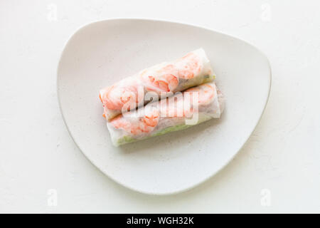 Vista dall'alto di Nem cuon (fresco nem vietnamita rotolo con gamberetti, Mango e zenzero) sulla piastra bianca su una lavagna bianca Foto Stock
