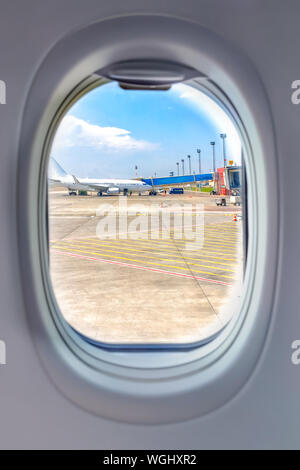 La vista dalla finestra dell'oblò di un aereo all'aeroporto. Foto Stock