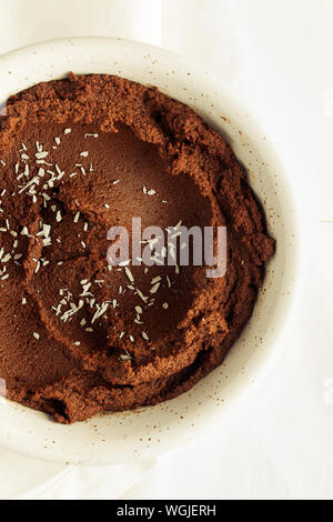 Snack sani di greggio in casa brownie al cioccolato dessert hummus fatta con ceci,cacao e cocco o latte di mandorla su sfondo bianco di close-up Foto Stock