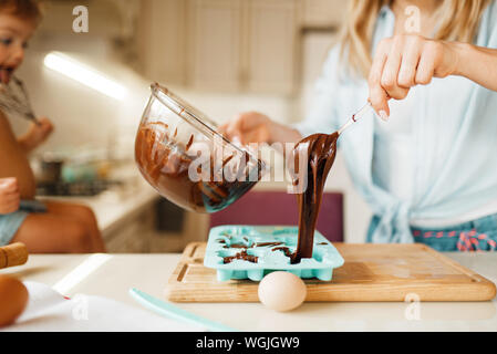 La madre e il bambino per la cottura e i gusti di cioccolato fuso Foto Stock