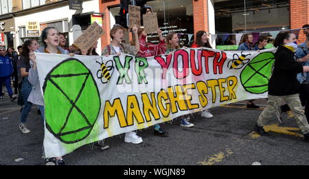 Un gruppo dalla ribellione di estinzione i giovani che arrivano con il loro banner su Deansgate come ribellione settentrionale manifestanti, parte del movimento globale estinzione della ribellione, bloccato Deansgate nella zona centrale di Manchester, UK, il 1 settembre, 2019 il terzo giorno di quattro giorni di protesta. I manifestanti chiedono che il governo dice la verità circa l'emergenza climatica, interviene ora, ed è guidato da una assemblea dei cittadini sul cambiamento climatico. Foto Stock