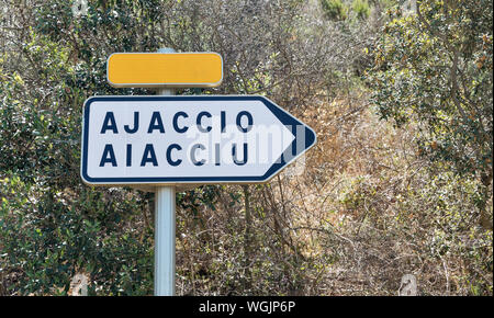 Ajaccio cartello stradale. Freccia bianca con la città di destinazione nome, copia gialla della piastra dello spazio. La Corsica, Francia. Foto Stock