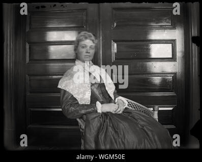 Ritratto di donna nella sedia di vimini indossando storico stile coloniale abito. Inizio periodo edoardiano fotografia amatoriale, scandita dall'originale 3x4 pollici lastra di vetro negativo circa primi 1900s. Foto Stock