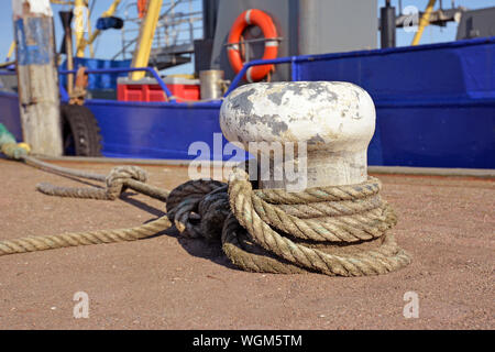 Bollard con accappatoio attaccato ad esso per fissare la barca ancorata nel porto di Oudeschild su isola di Texel in nel nord dei Paesi Bassi Foto Stock