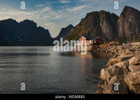 Bella piccola casa in un lago o in un grande fiume con sfondo di montaggio Foto Stock