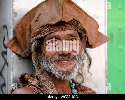 Robusto uomo anziano indossa una veste indossata brown Jack Sparrow tricorno cappello e sorrisi per la fotocamera. Foto Stock