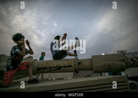 (190901) -- MISURATA (Libia), Sett. 1, 2019 (Xinhua) -- bambini libici giocare su serbatoi distrutti in misurata, a circa 200 km a est di Tripoli, in Libia, il 7 settembre 1, 2019. (Foto di Amru Salahuddien/Xinhua) Foto Stock