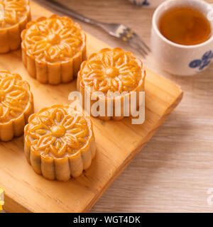 La torta della luna con tè sul luminoso tavolo in legno e serve provare, concetto di vacanza del Mid-Autumn Festival del cibo tradizionale layout design, vicino, copia spac Foto Stock