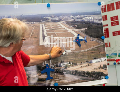 21 agosto 2019, Assia, Frankfurt/Main: Jens Peters (60), Vice Capo della formazione del conducente all'aeroporto di Francoforte, spiega le regole sul piazzale di sosta su una mappa. La guida in pista richiede una distinta licenza di guida che può essere acquisito in una due giorni di formazione teorica e pratica di corso presso la società operativa Fraport. Foto: Frank Rumpenhorst/dpa Foto Stock