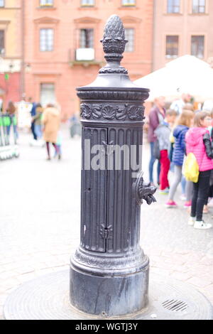 Pompa dell'acqua tradizionale azionata a mano nella piazza del mercato della città vecchia a Varsavia, Polonia Foto Stock