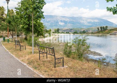 Legno vuota una panchina nel parco affacciato sul lago Viroi in Argirocastro, Albania. Foto Stock