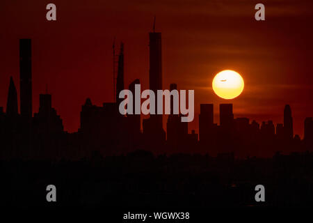 Pechino, USA. Il 30 agosto, 2019. Tramonto su Manhattan è raffigurato da Arthur Ashe Stadium nel Queens, a New York, gli Stati Uniti, il 30 agosto 2019. Credito: Li Muzi/Xinhua/Alamy Live News Foto Stock