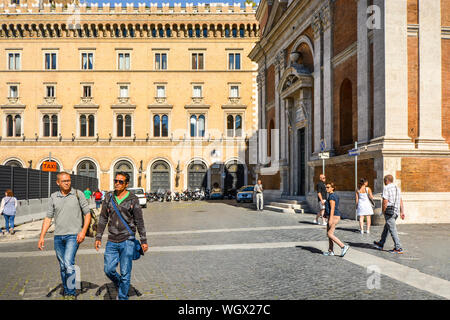 Due uomini italiani a piedi passato la Chiesa di Santa Maria di Loreto chiesa vicino a Colonna di Traiano nella parte storica di Roma, Italia Foto Stock