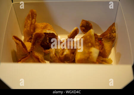 Croccante fritti, i wonton riempiti con la crema di formaggio in una scatola di asporto Foto Stock