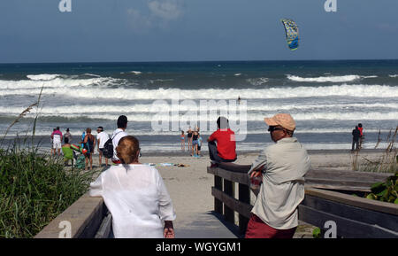 Indialantic Beach, Florida, Stati Uniti d'America. 1 Sep, 2019. Spiaggia-frequentatori guardare come un uomo kiteboards nel pesante surf generato dall uragano Dorian. La categoria 5 storm è atteso a venire pericolosamente vicino alle coste della Florida come presto come domani notte. Credito: Paul Hennessy SOPA/images/ZUMA filo/Alamy Live News Foto Stock