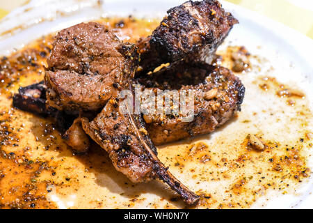 Ben fatto costata di manzo in grasso piastra bianca. La bistecca con tenera la cottura è ben fatto e sta brillando con i succhi di frutta essiccamento sulla piastra bianca. Foto Stock