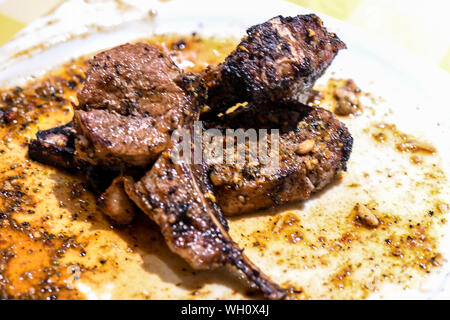 Ben fatto costata di manzo in grasso piastra bianca. La bistecca con tenera la cottura è ben fatto e sta brillando con i succhi di frutta essiccamento sulla piastra bianca. Foto Stock