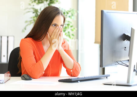 Preoccupato imprenditrice scioccato dopo la scoperta di errore sul computer in ufficio Foto Stock