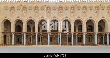 Corridoio arcuato che circondano il cortile della pubblica antica moschea di Sultan Al Moaayad, vecchio Cairo, Egitto Foto Stock