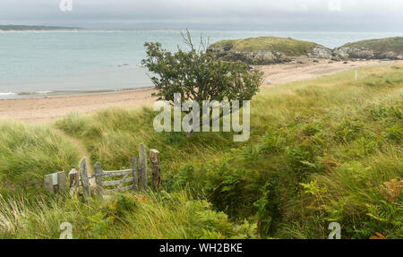 Una vista di una piccola baia e cancello sulla isola di Llanddwyn, Anglesey, Galles del Nord, Regno Unito.prese il 22 agosto 2019. Foto Stock