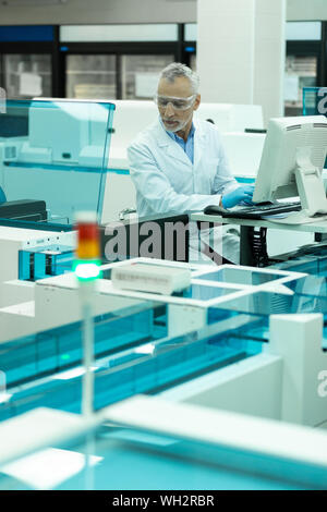 Lieto uomo maturo computer di test in laboratorio Foto Stock