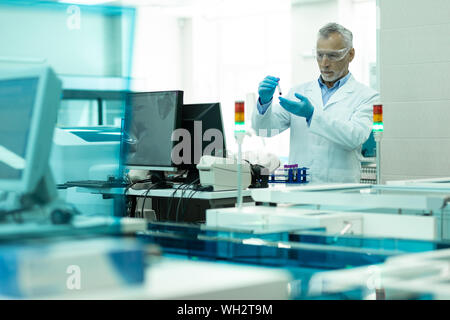 Concentrato maschio senior persona che lavora in laboratorio Foto Stock