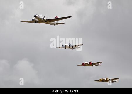 La Swissair Douglas DC-3 'N431HM' volare in formazione con 3 Beechcraft Model 18's al Flying Legends su Airshow xiv Luglio 2019 Foto Stock