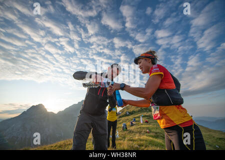 Zorzone, Serina, Italia 1 Septemper 2019: Europeo Skymarathon campionato. Approvvigionamento di acqua per atleta presso il punto di ristoro Foto Stock