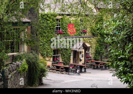 Una tranquilla stradina che conduce al Sun Inn storico pub e hotel. Coniston, Cumbria, Regno Unito, Gran Bretagna Foto Stock