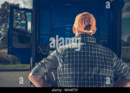 Giovane Conducente di autocarri ottenere lavoro. Pronto per il primo viaggio in moderno semi carrello. Industria dei Trasporti Tema. Foto Stock