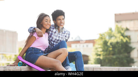 Sorridente adolescenti godendo data nella città, seduti sulle scale Foto Stock