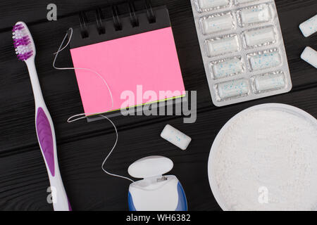 Accessori per la cura dei denti su sfondo nero. Foto Stock