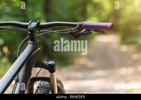 Immagine ritagliata di sport bike manubrio su sfondo di foresta Foto Stock
