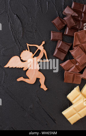 Figura di legno di coppe e pezzi di cioccolato. Foto Stock