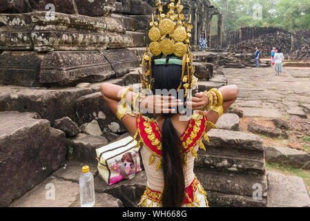 Apsara ballerini preparando a svolgere delle danze tradizionali in un cortile del tempio Bayon in Siem Reap, Cambogia Foto Stock