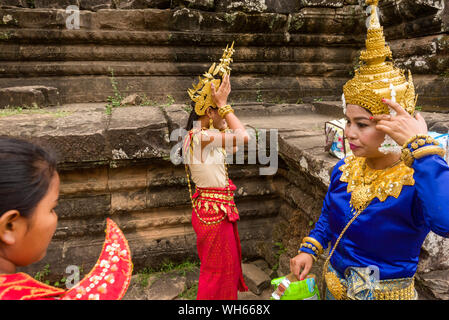 Apsara ballerini preparando a svolgere delle danze tradizionali in un cortile del tempio Bayon in Siem Reap, Cambogia Foto Stock
