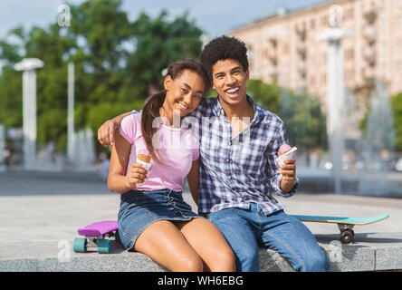 Allegro adolescenti aventi data in città a mangiare il gelato Foto Stock