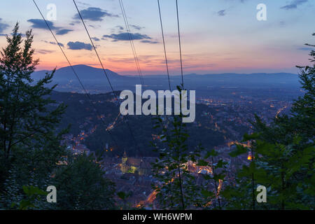 Vista notturna su Brasov, sotto le ultime luci del tramonto Foto Stock