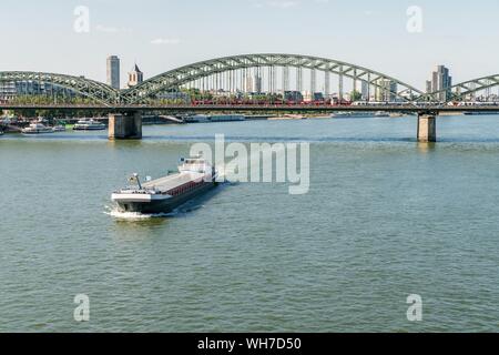 Nave da carico sul Reno off ponte di Hohenzollern, Colonia, nella Renania settentrionale-Vestfalia, Germania Foto Stock