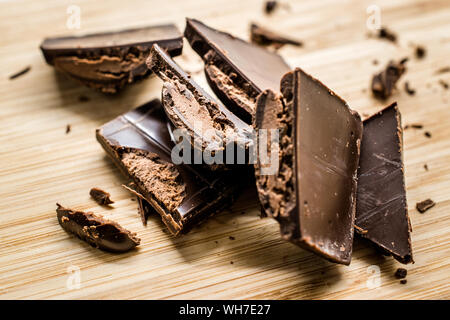 La Ganache cioccolato ripieno Bar pezzi sulla tavola di legno pronta da mangiare. Snack dolci. Foto Stock