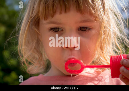 Bambino di 3 anni a soffiare bolle Foto Stock