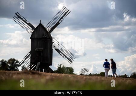 02 settembre 2019, Bassa Sassonia, Gifhorn: due donne corrono verso un mulino del museo del mulino Gifhorn. Foto: Sina Schuldt/dpa Foto Stock