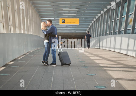 Foto a lato di coccole l uomo e la donna in una fase di transizione in aeroporto Foto Stock