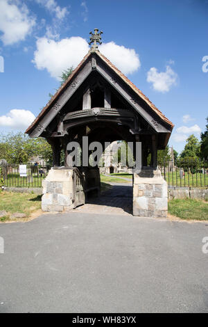 Il Lychgate presso il St James Church di Avebury, Wiltshire risalente al 1899 e comprendente un pesante telaio in legno su base di pietra calcarea di pareti con un tetto di tegole. Foto Stock