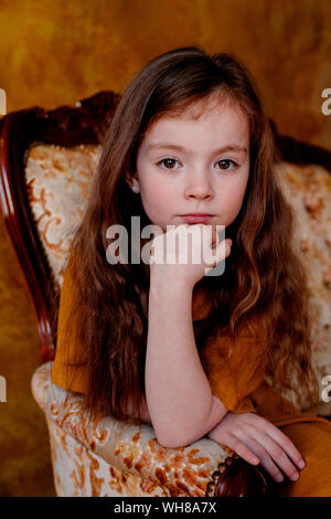 Ritratto di bambina seduti sulla sedia a sdraio Foto Stock
