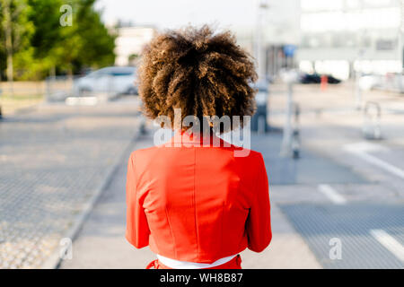 Vista posteriore della giovane donna alla moda da indossare tuta rossa camicia Foto Stock